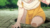 a woman in a yellow dress is kneeling down on the ground