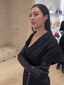 a woman in a black dress and black gloves
