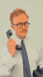 a man wearing glasses and a tie is holding a phone