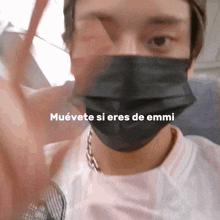 a man wearing a mask with muevete si eres de emmi written on the bottom right