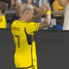 a soccer player wearing a yellow jersey with the number 7 on it