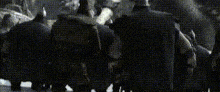 a group of people are standing next to each other in front of a statue of a dragon .