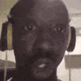a man is wearing headphones and making a funny face .