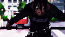 a man in a black shirt is holding a sword in his hands .