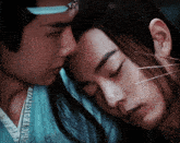 a man with long hair is laying on another man 's shoulder