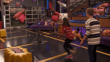 a woman is holding a bag over her head while another woman falls on the floor