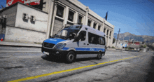 a police van drives down a street in front of a building