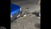 a blue car with a license plate that says tnk 4735 is parked on the side of the road
