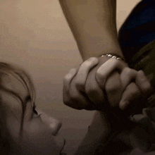 a person holding another person 's hand with a ring on their wrist