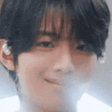 a close up of a person 's face with a blurred background and a smile .