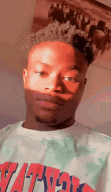 a young man wearing a t-shirt with the word nation on it .