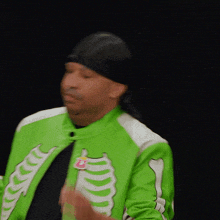 a man wearing a green skeleton jacket and a black head scarf