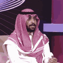 a man with a beard wearing a red and white scarf around his head