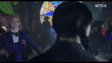 a girl in a purple striped jacket and bow tie is smiling at a man in a black hat ..