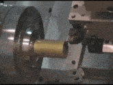 a close up of a machine cutting a brass pipe