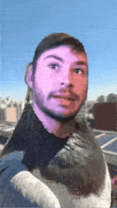 a man with a beard is holding a bird in his arms