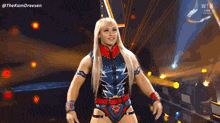 a woman in a wrestling costume is walking on a stage .