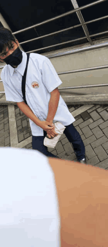 a man wearing a mask and a white shirt has a badge on his shirt that says ' a ' on it