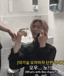 a man in a black shirt is making a funny face in a bathroom with chinese writing on the wall