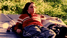 a woman in a red and white striped sweater is laying on a bed