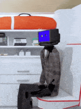 a cartoon character with a blue box on his head sits in a room