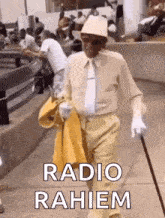 a man in a hat and tie is walking down the street with a cane and a yellow jacket .
