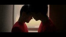 two men in red shirts look at each other