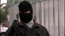 a man wearing a black mask and holding a gun