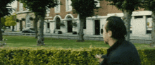 a man stands in front of a brick building with a sign that says ' a & a '