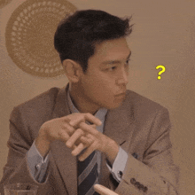 a man in a suit and tie has a question mark around his neck