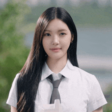 a girl wearing a white shirt and tie is looking at the camera