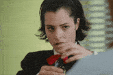 a woman wearing a black suit and a red tie