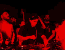 a man in a black shirt with the letter x on it is playing music