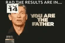 a man is standing in front of a tv screen with the words `` you are the father '' on it .