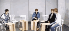 a group of young men are sitting at tables in a room .