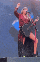 a woman is singing into a microphone while holding a guitar ..