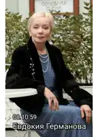 a woman in a blue dress is sitting at a table in front of a sign that says ' основная сцена '
