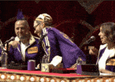 a man in a purple jacket has a name tag that says " kinggler "