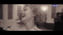 a black and white photo of a woman laughing with her head in the air .