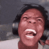 a man wearing headphones is screaming with his mouth open