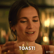 a woman is toasting with a glass of wine and the word toast is visible