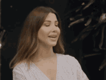 a woman wearing a white top with holes in it is smiling