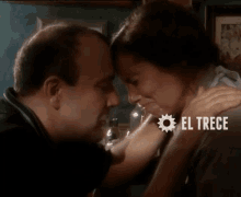 a man and a woman are touching their foreheads with el trece in white letters