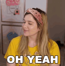 a woman wearing a yellow shirt and a pink headband says oh yeah