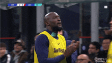 a man wearing a yellow le lege jersey applauds