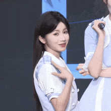 a girl in a blue dress holds a microphone