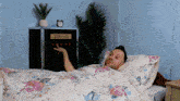 a man laying in a bed with a service box in the background