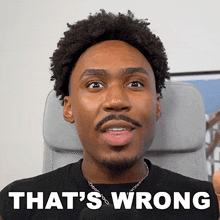a man sitting in a chair with the words that 's wrong written on his face