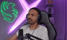 a man is sitting in a chair wearing headphones and a microphone .