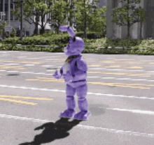 a purple bunny is walking down a street